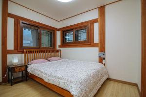 Un dormitorio con una cama y dos ventanas. en Eunpyeong Hanok Pyeonganchae, en Seúl