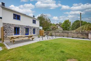 a wooden bench in a yard next to a building at La Maison Valnotte - Proche du port de Carteret in Barneville-Carteret