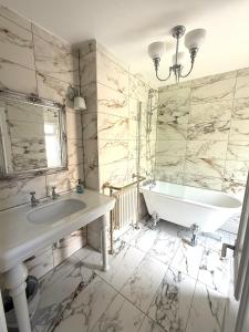 a white bathroom with a tub and a sink at Victorian Villa close to Liverpool City Centre in Liverpool