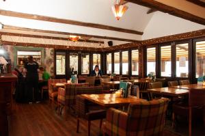 a restaurant with wooden tables and chairs and people in it at The Wiremill in Felbridge
