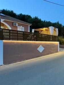 a wooden fence next to a road with a house at Divino Appartment in Zakynthos