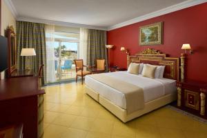 a bedroom with a large bed and red walls at Palm Royale Resort - Soma Bay in Hurghada