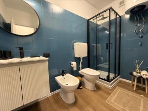 a bathroom with a toilet and a shower and a mirror at Appartamento Palu in Chiesa in Valmalenco