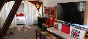 a living room with a couch and a large television at Phedra's House Spata- Artemida in Artemida