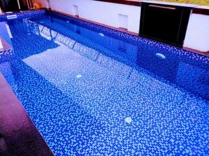 une piscine vide avec des carreaux bleus dessus dans l'établissement 3bhk Jannat Villa, à Lonavala