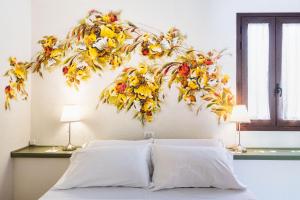 a bed with a flower arrangement on the wall at Villa Felicia in Noto +33 photos