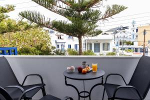 a small table with fruit and drinks on a balcony at Noe Rooms In Center Of Tinos in Tinos