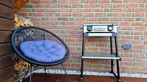 a wicker chair sitting next to a brick wall at Ferienwohnung "Friesentied" 35229 in Hesel