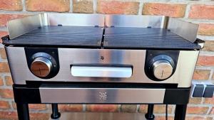 a toaster oven sitting on a stand next to a brick wall at Ferienwohnung "Friesentied" 35229 in Hesel