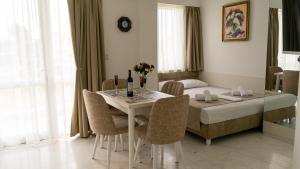 a room with a table and chairs and a bed at Fengari - Luxurious Apartments in Keramoti