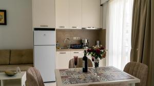 a kitchen with a table with a vase of flowers on it at Fengari - Luxurious Apartments in Keramoti