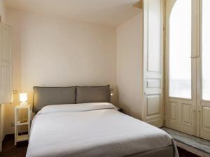 a white bed in a room with a window at Porticciolo sea view in Aci Castello