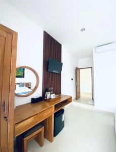 a bathroom with a wooden vanity and a mirror at D'Tulak House in Ubud