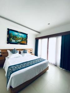 a bedroom with a large bed with blue curtains at D'Tulak House in Ubud +35 photos