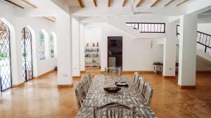 ワタムにあるKiboko Nyumbaのテーブルと椅子付きの広い白い部屋