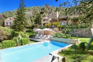 a swimming pool in the yard of a house at Buccara Noetzie - Pezula Castle in Knysna