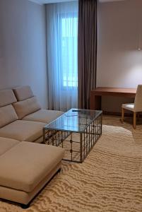 a living room with a couch and a glass coffee table at Embassy Romana in Bucharest