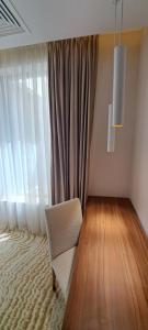 a room with a chair in front of a window at Embassy Romana in Bucharest