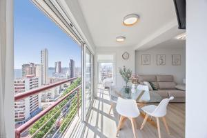 een woonkamer met een balkon met een tafel en stoelen bij Mucho Gusto Coblanca 3 in Benidorm