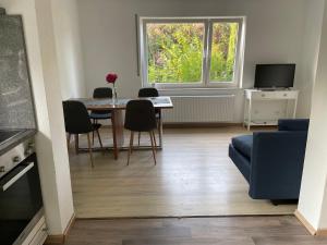 a living room with a table and chairs and a window at Ferienwohnung am Romberg in Lohr