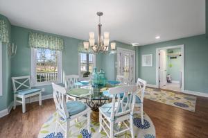 a dining room with a glass table and chairs at Barefoot Breeze in Deep Hole