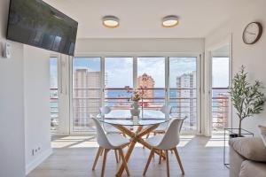 een eetkamer met een glazen tafel en witte stoelen bij Mucho Gusto Coblanca 3 in Benidorm +52 foto's