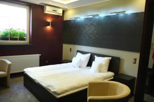 pokój hotelowy z łóżkiem i dwoma krzesłami w obiekcie Winiarnia w mieście Kwidzyn +37 zdjęć