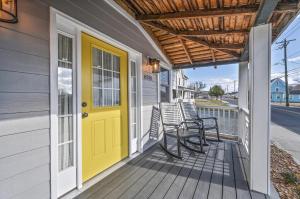 a front porch with chairs and a yellow door at Hudson House in Chincoteague