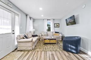 a living room with two couches and a table at Hudson House in Chincoteague