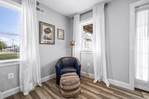 a living room with a chair and windows at Hudson House in Chincoteague +32 photos