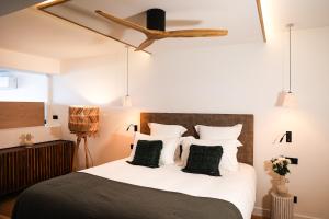 - une chambre avec un grand lit et des oreillers noirs et blancs dans l'établissement Residence Les Suites Pereire, à Arcachon 2 autres photos