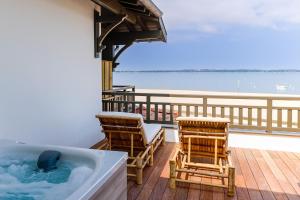 deux chaises et une baignoire sur une terrasse dans l'établissement Residence Les Suites Pereire, à Arcachon