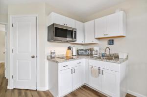eine Küche mit weißen Schränken und einer Mikrowelle in der Unterkunft Assateague Inn 106-S in Deep Hole