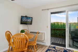 ein Esszimmer mit einem Tisch und Stühlen sowie einem Balkon in der Unterkunft Assateague Inn 106-S in Deep Hole