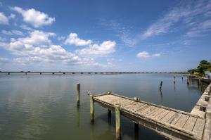 un molo su un corpo d'acqua con cielo nuvoloso di Sea Glass a Chincoteague