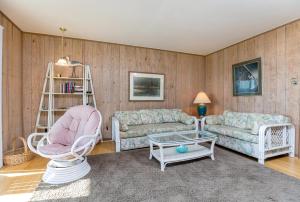 a living room with two couches and a table at Sunrise Sonata in Birch Town