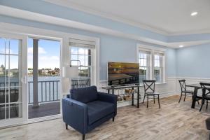 a living room with a table and chairs and a tv at At The Waters Edge in Chincoteague