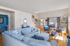 een woonkamer met een blauwe bank en stoelen bij The Baywatch Bungalow in Greenbackville