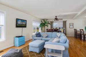 een woonkamer met een blauwe bank en een tv bij The Baywatch Bungalow in Greenbackville