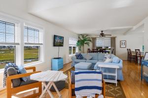 een woonkamer met een blauwe bank en stoelen bij The Baywatch Bungalow in Greenbackville