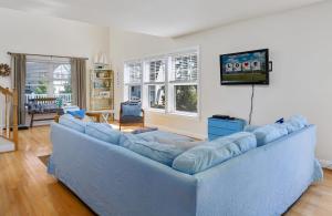 een woonkamer met een blauwe bank en een tv bij The Baywatch Bungalow in Greenbackville +32 foto's