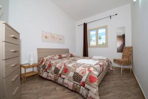 a bedroom with a bed and a dresser and a chair at Villa Marika in Fontane Bianche +44 photos