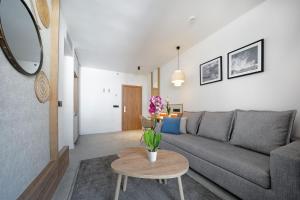 a living room with a gray couch and a table at HOVIMA Suites Costa Adeje in Adeje
