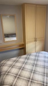 a bedroom with a bed with a plaid blanket at Waterside Haven at Cleethorpes Beach Free Wi-Fi 2 Toilets in Cleethorpes