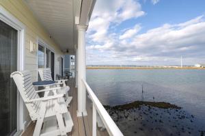 a porch with chairs and a table and the water at Sunset Bay Villa 220 - Vista Costiera in Chincoteague +32 photos