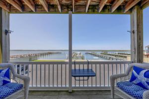 a porch with two chairs and a view of the ocean at Water's Edge in Chincoteague