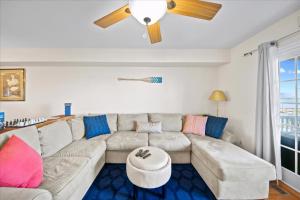 a living room with a couch and a ceiling fan at Water's Edge in Chincoteague +32 photos