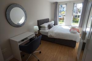 a bedroom with a bed and a desk and a mirror at Stockmans Stay, Belfast in Belfast