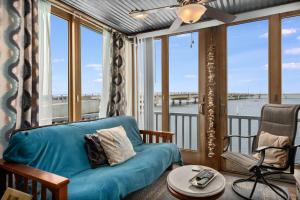 a living room with a couch and a balcony at Waterfront Sunsets in Chincoteague