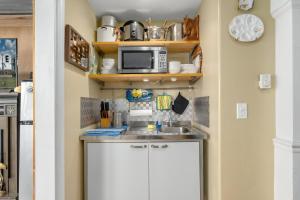 a kitchen with a sink and a microwave at Waterfront Sunsets in Chincoteague +12 photos